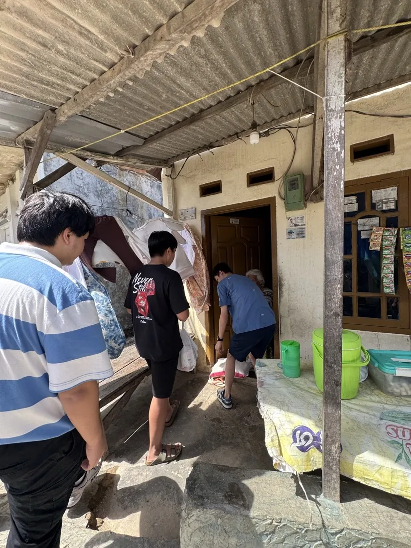 Volunteers gather at a doorway to drop off bags of supplies