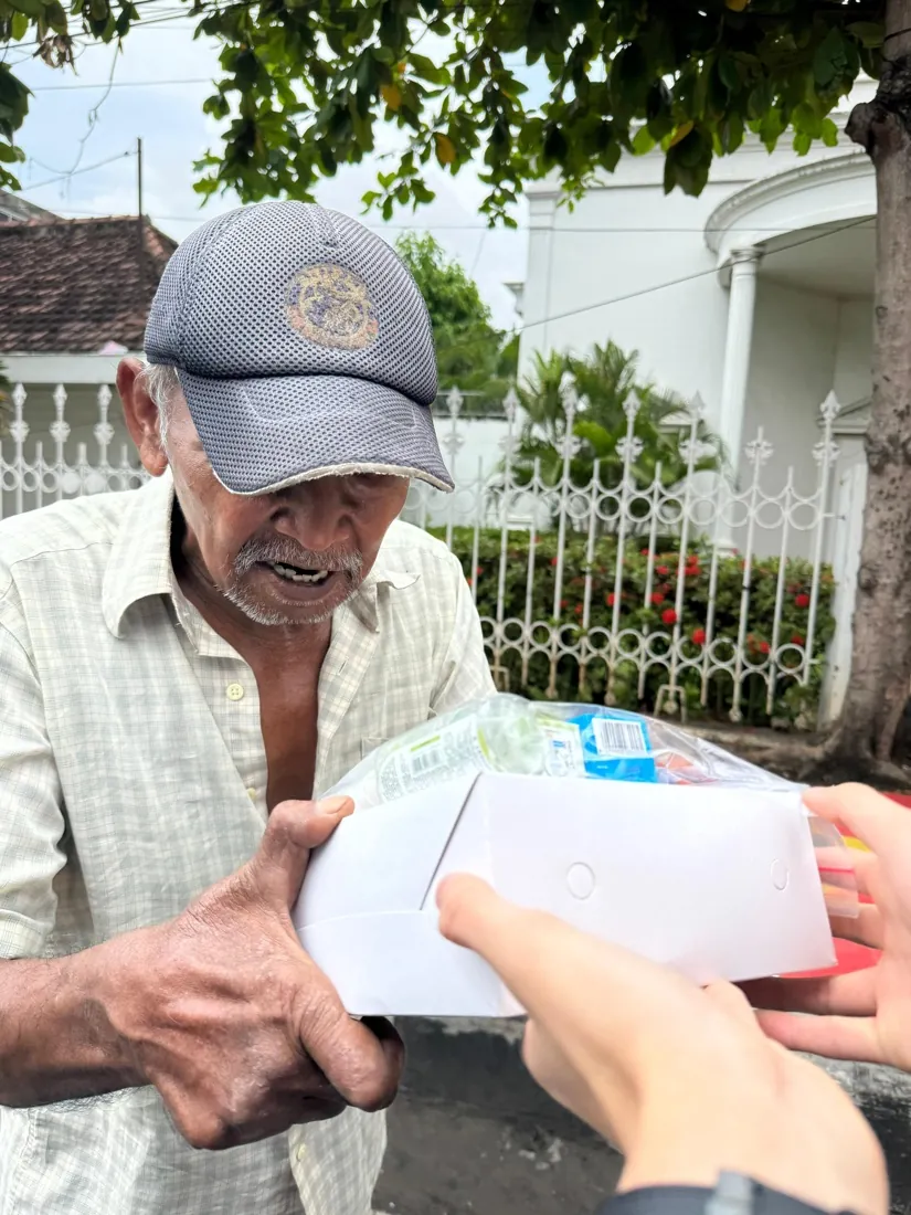 A man in a grey cap receives a care package