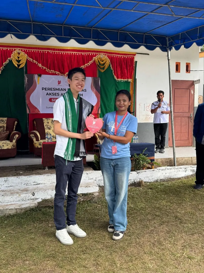 Bryan Wu receives a heart-shaped thank-you plaque at the opening ceremony at SD Anugerah